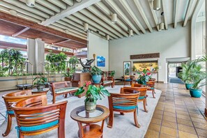 A spacious indoor area with wooden furniture, potted plants, and a high ceiling with exposed beams. - Amazing condo in beautiful Kailua-Kona!
Ocean-Front, right on the water's edge. (Kailua-Kona)