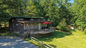 Une cabane dotée d’une terrasse, d’un patio couvert et d’une allée en gravier.