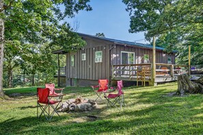 A rustic cabin with a deck, surrounded by trees and equipped with outdoor seating. - Luray retreat - Hiking and Shenandoah River nearby - Dog friendly (Page County)