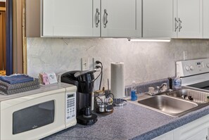 A kitchen with a microwave, coffee maker, kettle, and a sink. - Luray retreat - Hiking and Shenandoah River nearby - Dog friendly (Page County)