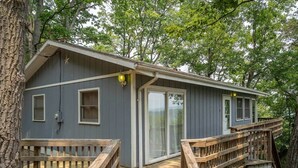 Een chalet met een terras, een raam en een deur.