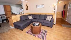 A living room with a sectional sofa, a wooden coffee table, and a kitchen in the background. - Scenic Views / Hike, kayak nearby / Dog friendly (Page County)