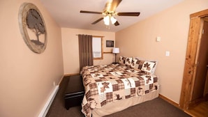 A bedroom with a bed, a ceiling fan, a window with curtains, a wall-mounted air conditioner, and a door. - Scenic Views / Hike, kayak nearby / Dog friendly (Page County)