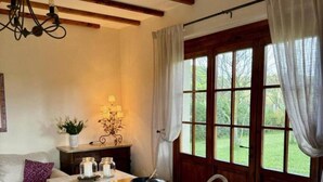 A kitchen with a built-in island, a wooden ceiling, and a large window with curtains.
