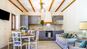 Un espacio habitable compacto con comedor, kitchenette y zona de estar.