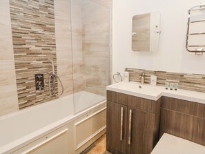 A modern bathroom with a glass-enclosed shower, a vanity with a mirror, and a wooden cabinet. - Abraham (Matlock)