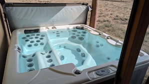Un spa portatif doté de plusieurs jets, d’un panneau de commande et d’un couvercle.