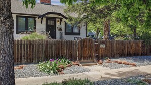 A house with a wooden fence, a front door, and a small porch.