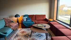 Un salon moderne avec un canapé, une table basse et une lampe.