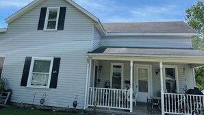 A two-story house with a porch, a visible mailbox, and a number '325' on the side. - Relax. Breathe. Enjoy. (Berea)