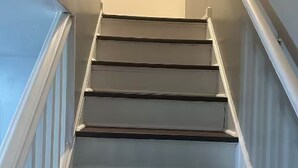 A staircase with white railings and dark steps. - Relax. Breathe. Enjoy. (Berea)