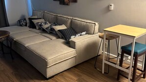 Una sala de estar moderna con un sofá, una mesita y un cuadro en la pared.