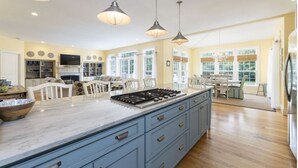 A spacious kitchen with a large island, pendant lighting, and a view to the dining area. - Large, 4,300 sq. ft. custom built 5 BR home on private 2.2 acres in Watch Hill (Westerly)