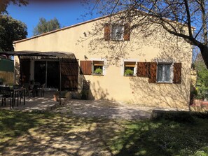 Un bâtiment doté d’un patio, d’un espace extérieur aménagé pour s’asseoir et d’une structure à toit de chaume.