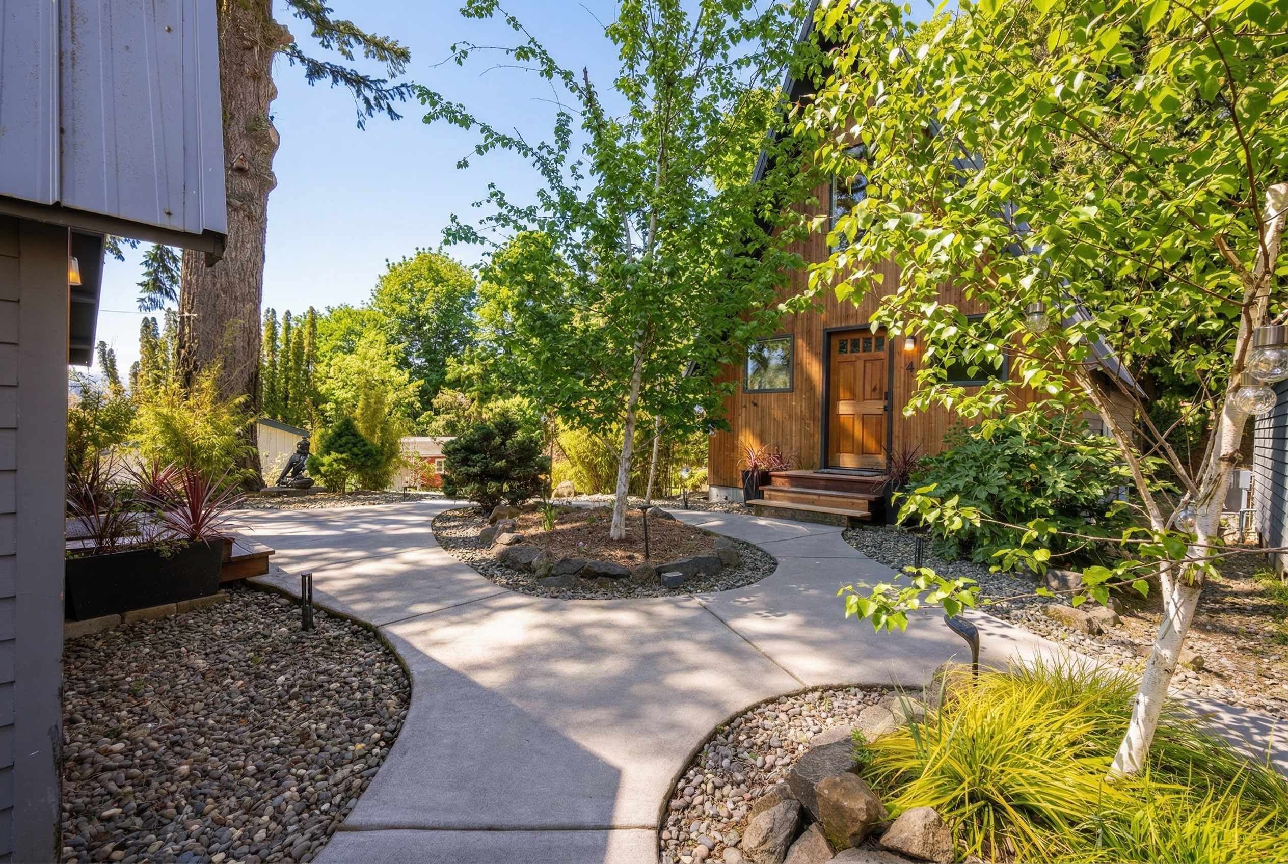 A landscaped courtyard with a central pathway, surrounded by trees and shrubs.