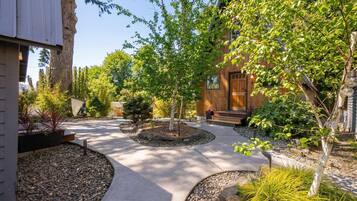 A landscaped courtyard with a central pathway, surrounded by trees and shrubs.