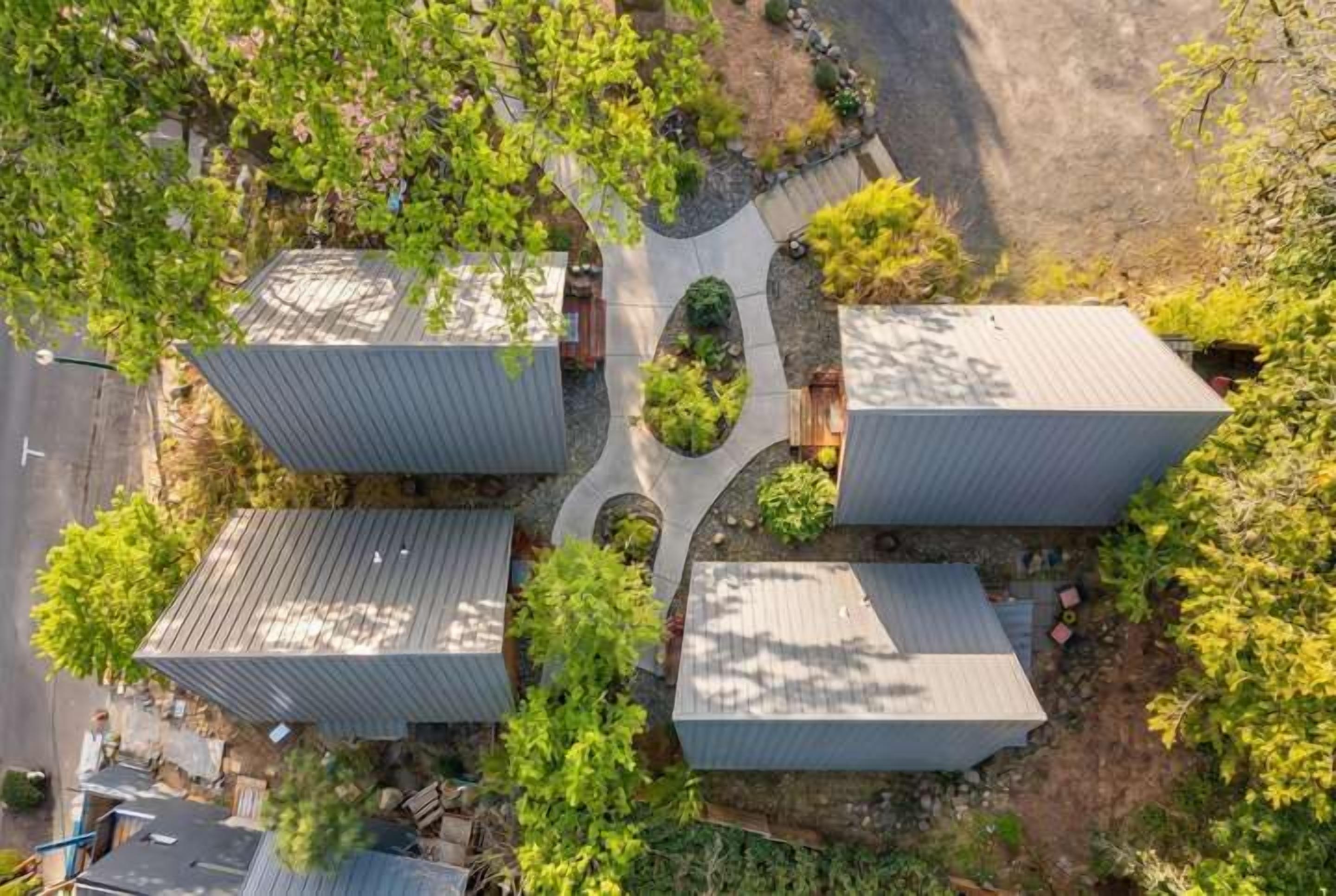 Un bâtiment moderne doté d’une cour intérieure, entourée de verdure et bordée d’une allée pavée.