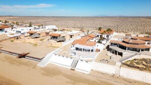 Un village côtier aux bâtiments blancs, bordé de palmiers et doté d’une plage.