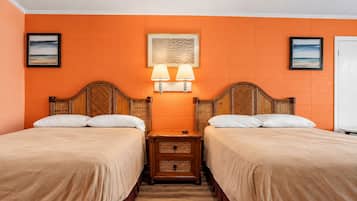 Een hotelkamer met twee bedden, een nachtkastje, een wandlamp en ingelijste foto's.