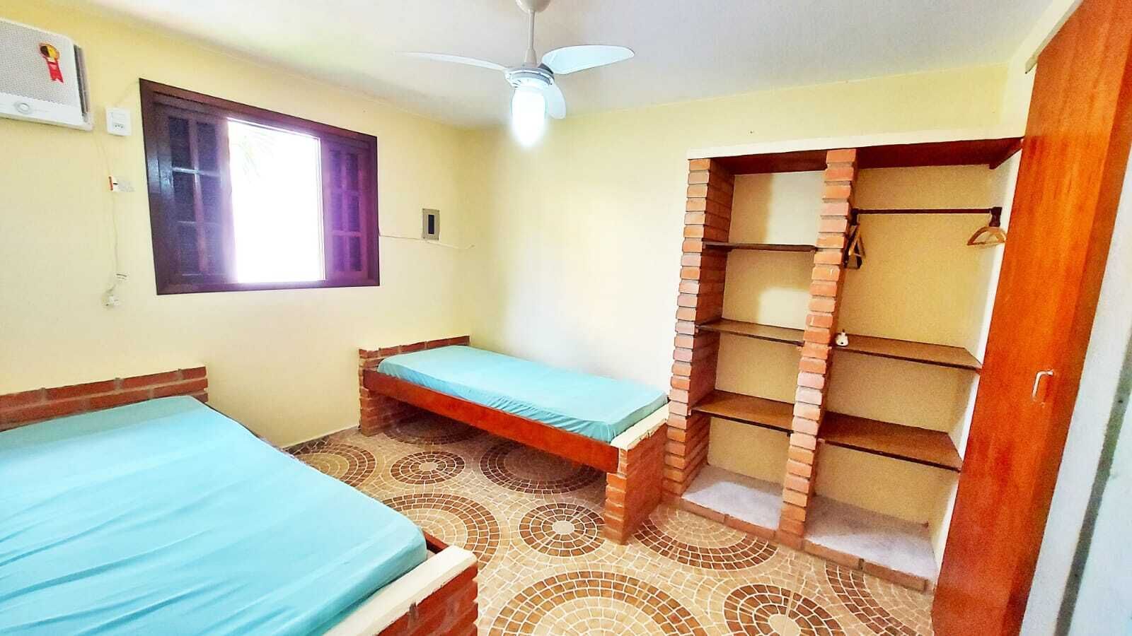 A room with a bed, a small table, a wardrobe, and a window.