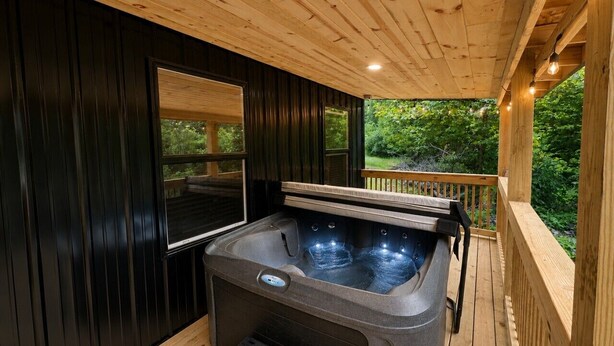 Un bain à remous installé sur une terrasse en bois, offrant une vue sur la verdure.