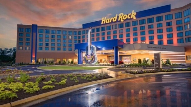 Ein Hard Rock Hotel mit einem großen Gebäude, einem Parkplatz und einem gepflegten Rasen.