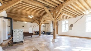 A spacious room with a high wooden ceiling, a fireplace, and a large window. - The Monastery - ORBAIS L'ABBAYE (ORBAIS L'ABBAYE)