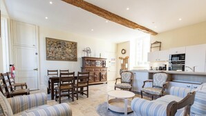A spacious living room with a dining area, a kitchen, and a fireplace. - The Monastery - ORBAIS L'ABBAYE (ORBAIS L'ABBAYE)