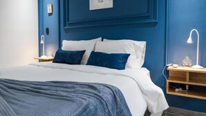 Ein Schlafzimmer mit einem Bett, Nachttischen und Wandbildern.