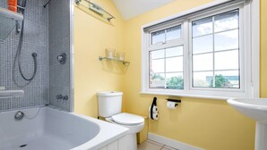 A bathroom with a bathtub, toilet, and window. - The Fox at Hurley - The Warren Suite (Maidenhead)
