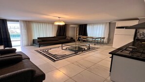 Een moderne woonkamer met een bank, salontafel en een eethoek.