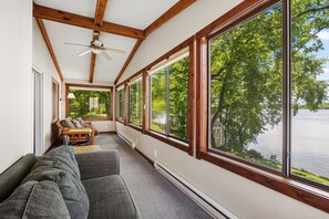En korridor med stora fönster, en takfläkt och en soffa.