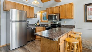 Une cuisine avec des meubles en bois, un réfrigérateur en acier inoxydable, un four à micro-ondes et une cuisinière.