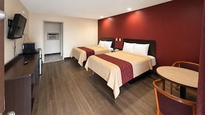 Een hotelkamer met twee bedden, een bureau, een stoel en een televisie.