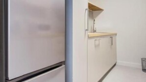 Una cocina con un refrigerador de acero inoxidable, una encimera de madera y un lavamanos.