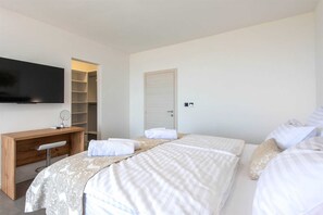 A hotel room with a bed, a desk, a television, and a wardrobe.