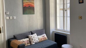 Et værelse med seng, radiator, et vindue og et billede på væggen.