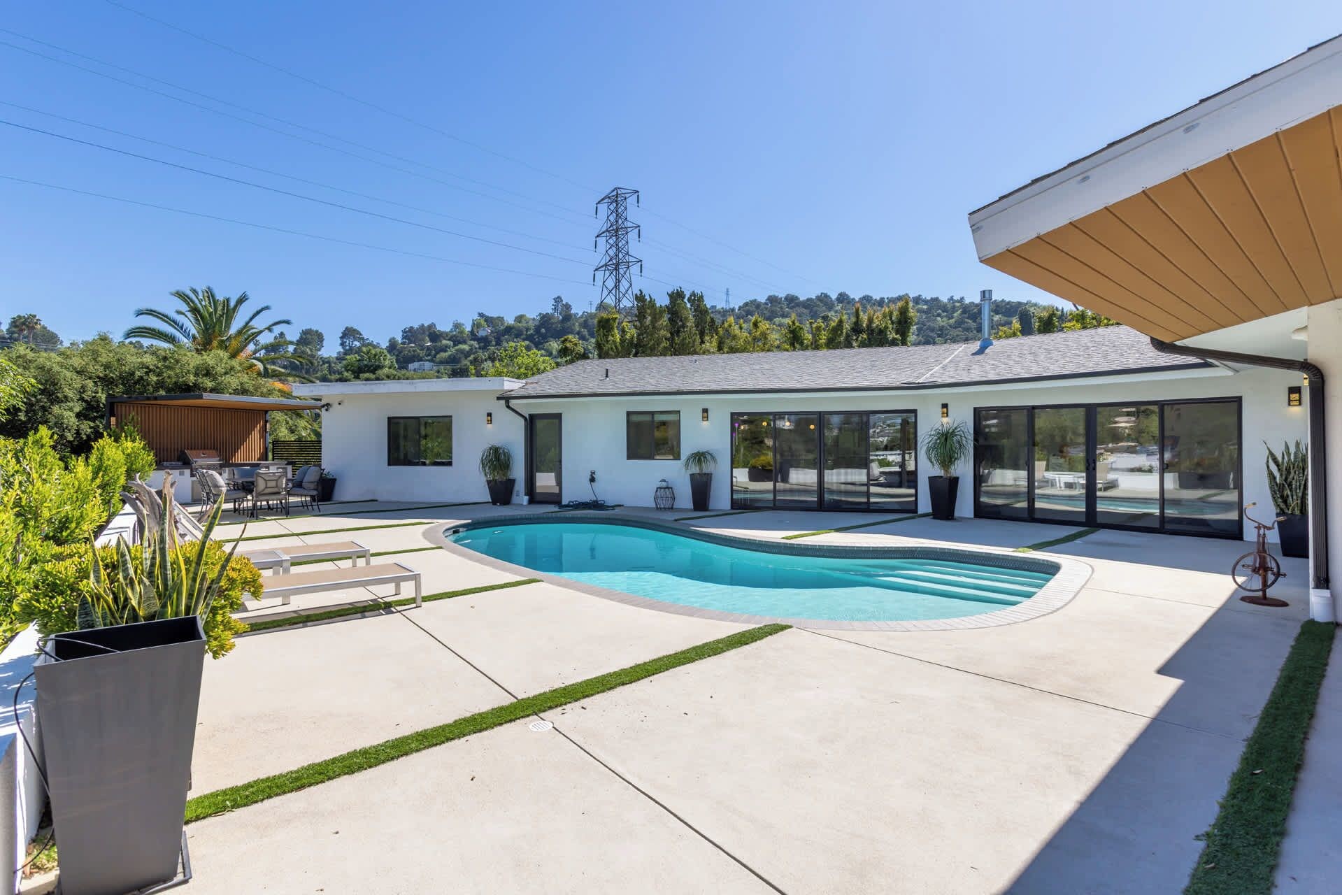 A modern house with a swimming pool, a covered patio, and a garage.