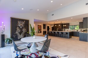 Cocina moderna con armarios oscuros, una isla central e iluminación colgante.