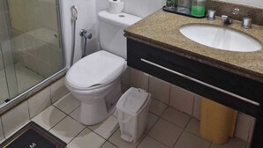 A bathroom with a glass shower enclosure, a toilet, a sink with a granite countertop, and a mirror. - Lindo Apto algumas quadras da Paulista (São Paulo)