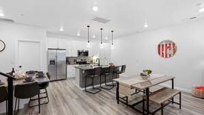 Une cuisine moderne dotée d’un îlot central, d’un coin repas avec un banc et d’une décoration murale ronde.
