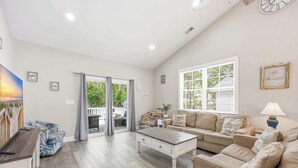 A spacious living room with a sofa, a coffee table, and a television. - Salty Seagull Pet Friendly Beach House (Myrtle Beach)