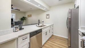 Una cucina moderna con lavastoviglie, frigorifero in acciaio inossidabile e un lucernario.
