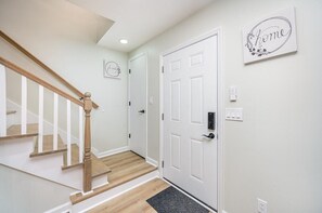 A staircase with wooden steps and white railings, a white door with a lock, and a wall-mounted sign with the word 'home'. - Pet Friendly Tidal Retreat Steps to Sand (Myrtle Beach)