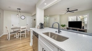 Una cucina moderna con un'isola grande, mobili bianchi e lavastoviglie integrata.