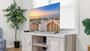 Un téléviseur posé sur un meuble en bois, avec une scène de plage à l’écran.