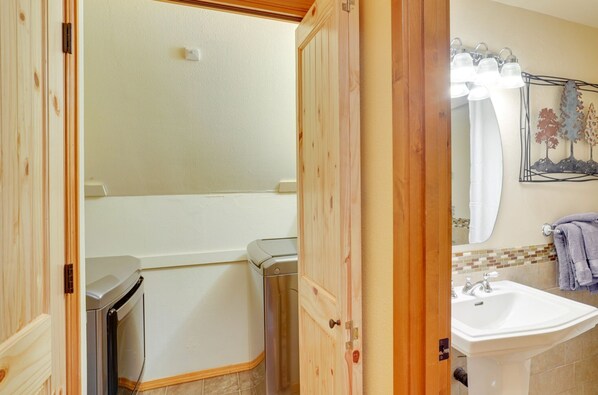 Een badkamer met een witte wastafel, een spiegel en een douchegordijn.