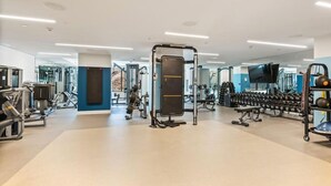 Een moderne sportschool met diverse fitnessapparaten, waaronder krachttoestellen en gewichten.
