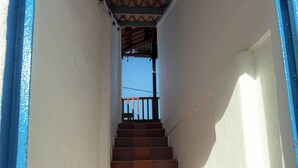 Eine Treppe mit Terrakotta-Stufen, die zu einem Balkon führt.