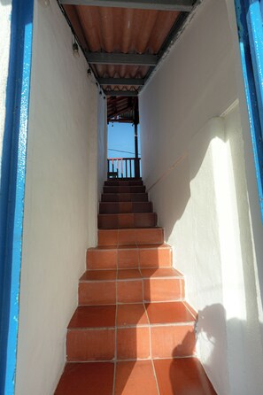 A staircase with terracotta steps leading to a balcony. - Cozy Island Home. Ocean View. Pool. Kitchen. (Taboga)